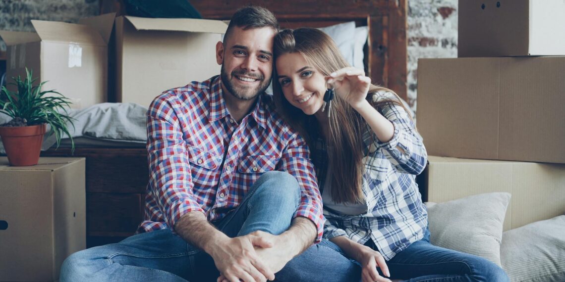happy couple holding keys in new home